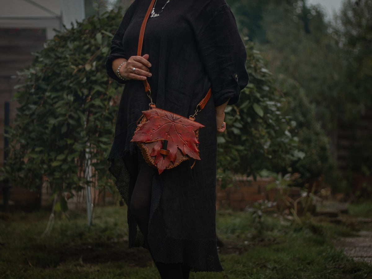 Ahornblatt Ledertasche mit langem Schulterriemen seitlich am Körper getragen.