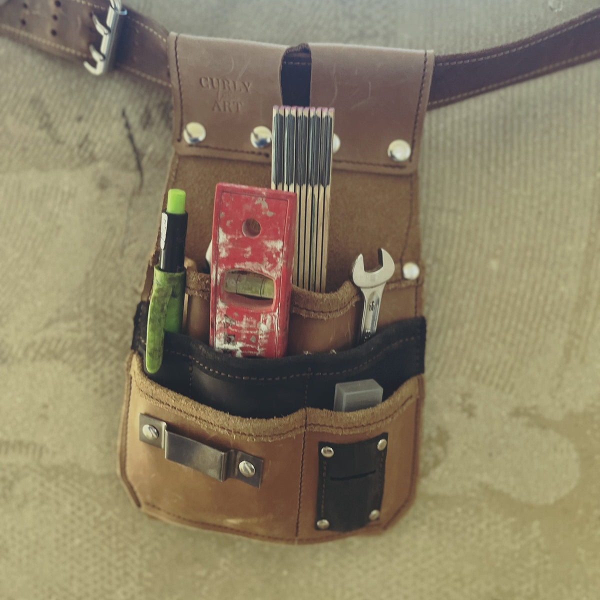 Braune Allround-Werkzeugtasche am Ledergürtel mit Zollstock, Wasserwaage, Stift und Schraubenschlüssel
