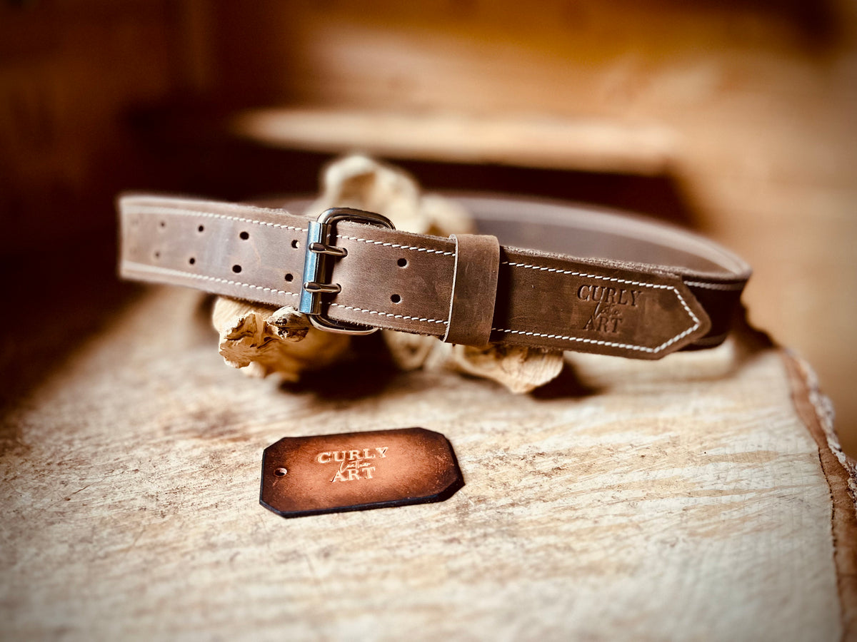 Brauner Arbeitsgürtel aus Leder mit Doppeldornschnalle, hellen Nähten und geprägtem Curly Leather Art Logo