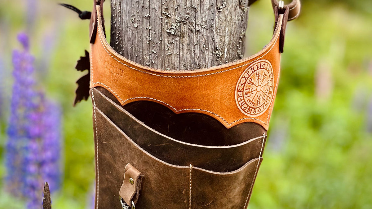 Detail der offenen Lederfächer und des Vegvísir-Motivs am Gartengürtel an einem Holzpfosten