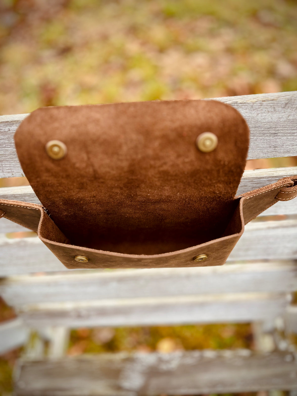 Geöffnete braune Ledertasche mit Blick in den Innenraum und auf die beiden Magnetverschlüsse.