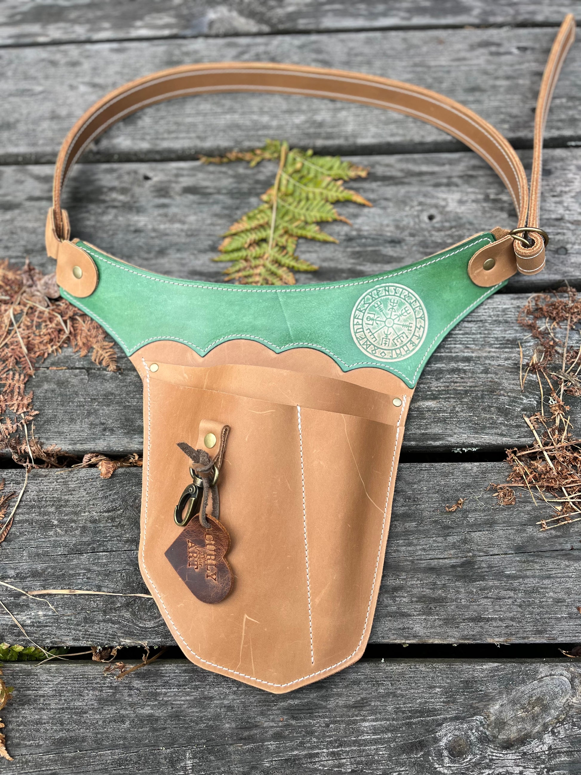 Hellbrauner Gartenwerkzeuggürtel mit grünem Vegvísir-Kranz und Karabiner auf Holz