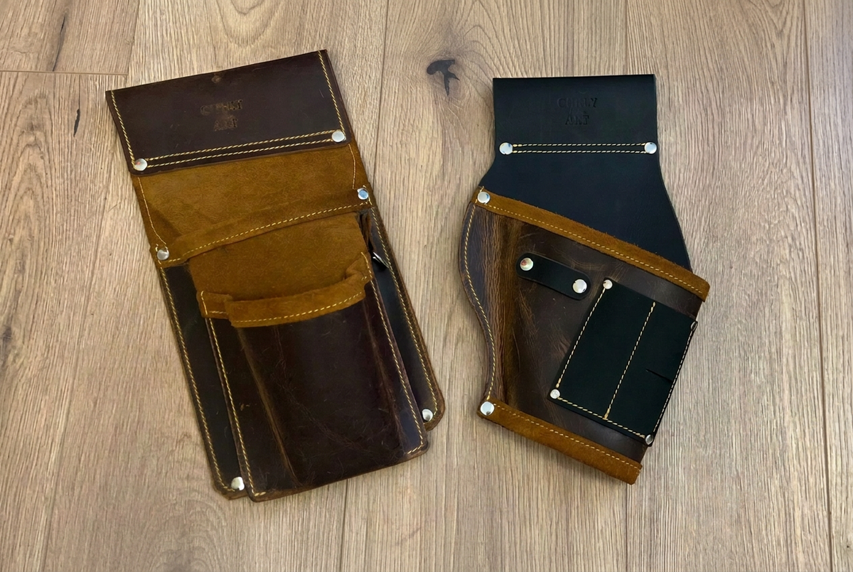 Montage-Erweiterungsset aus Leder mit dunkelbrauner Schraubentasche und schwarz-braunem Akkuschrauberhalter mit hellbraunen Akzenten auf hellem Holzboden