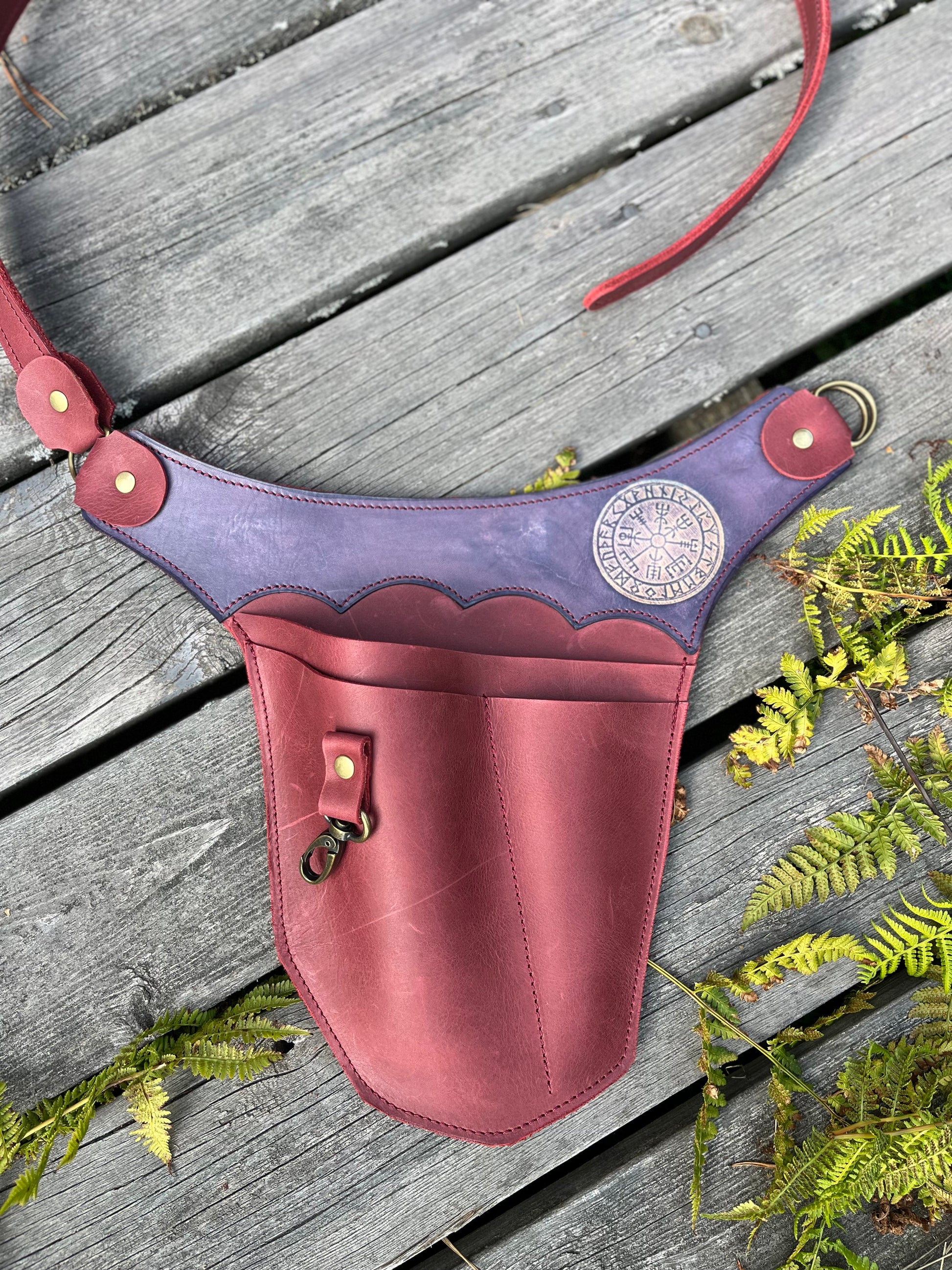 Weinroter Gartenwerkzeuggürtel aus Leder mit violettem Vegvísir-Kranz auf Holz