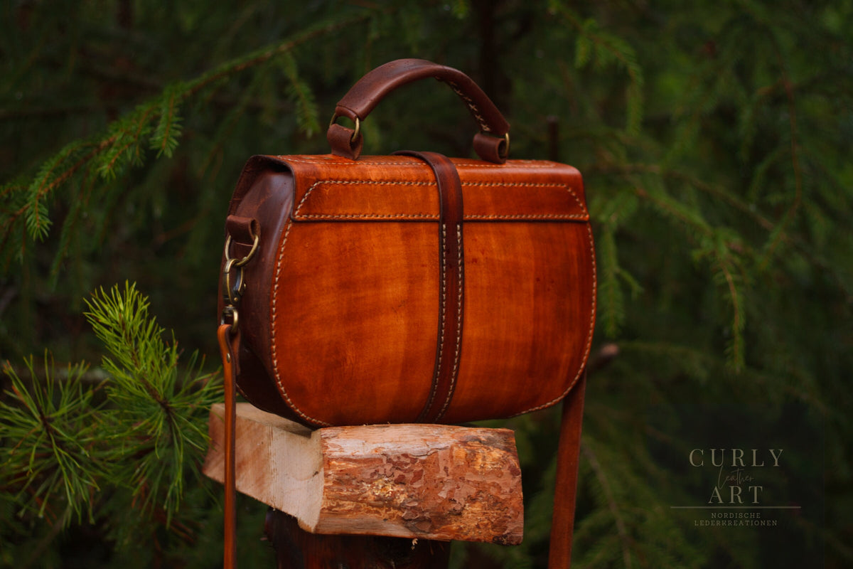 Rückansicht der Ledertasche Skadi mit sichtbaren Nähten, mittigem Lederriemen und Tragegriff.